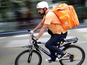 Former Afghan Communication Minister Sayed Sadaat rides a bicycle for his food delivery service job with Lieferando in Leipzig, Germany, Aug. 26, 2021.