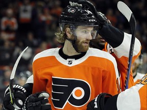 Philadelphia Flyers' Sean Couturier gets a pat on the helmet from teammate Wayne Simmonds after scoring a goal during the second period of a game against the Buffalo Sabres on  Jan. 7, 2018 in Philadelphia.