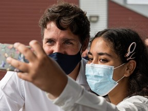 Liberal Prime Minister Justin Trudeau takes a selfie with a woman at Patro Roc-Amadour community centre during his election campaign tour in Quebec City, Aug. 26, 2021.