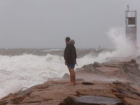 A man looks at waves during Tropical Storm Henri in Montauk, N.Y., Sunday, Aug. 22, 2021.