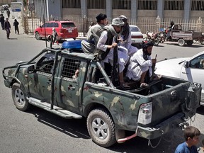 Taliban fighters are pictured in a vehicle of Afghan National Directorate of Security (NDS) on a street in Kandahar on August 13, 2021.