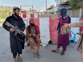 Taliban fighters stand guard at a check point in Farah, Afghanistan August 11, 2021.