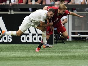 Atlanta United defender Brooks Lennon (left) battles with Toronto FC's Jacob Shaffelburg during the first half at Mercedes-Benz Stadium on Wednesday, Aug. 18, 2021.