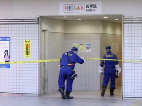 Police officers work at the site where a stabbing incident occurred on a train, at the Soshigaya-Okura station of the Odakyu Electric Railway in Setagaya Ward, Tokyo, Japan, Friday, Aug. 6, 2021.