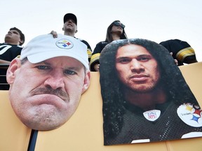 Fans hold cutouts of Steelers hall of fame members Bill Cowher (left) and Troy Polamalu (right) before a game between the Cowboys and the Steelers at Tom Benson Hall of Fame Stadium in Canton, Ohio, Thursday, Aug. 5, 2021.