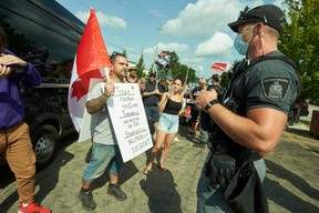 Protesters gather at a Liberal campaign event with Justin Trudeau at VeriForm Inc. in Cambridge, Ont., Sunday, Aug. 29, 2021.