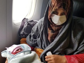 Afghan evacuee Soman Noori holds her newborn baby girl named Havva on board an evacuation flight operated by Turkish Airlines from Dubai to Britain's Birmingham, Aug. 28, 2021.