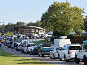 Travellers line up to enter Canada as border restrictions are loosened to allow fully vaccinated U.S. residents, after the COVID-19 pandemic forced an unprecedented 16-month ban that many businesses complained was crippling them, at the Peace Arch border crossing in Surrey, B.C., Aug. 9, 2021.