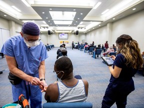 A healthcare worker from Humber River hospital's mobile vaccination team administers the Moderna COVID-19 vaccine at The Church of Pentecost Canada in Toronto, May 4, 2021.