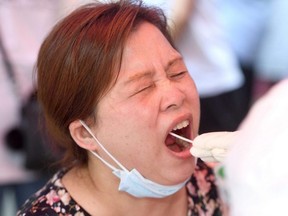 A resident is given a nucleic acid test for the coronavirus in Wuhan in China's central Hubei province, Tuesday, Aug. 3, 2021.