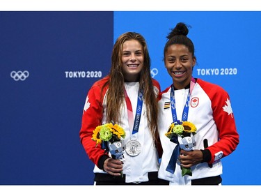 Canada's Jennifer Abel (R) and Canada's Melissa Citrini Beaulieu pose with their silver medals on the podium after coming second in the women's synchronised 3m springboard diving final event during the Tokyo 2020 Olympic Games at the Tokyo Aquatics Centre in Tokyo on July 25, 2021. (Photo by Jonathan NACKSTRAND / AFP)