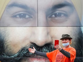 A supporter of the NDP takes a selfie outside party Leader Jagmeet Singh's bus before an election campaign tour stop at Transfer Beach Park in Ladysmith on Aug. 30.