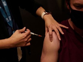 A nurse immuniser administers the AstraZeneca vaccine to a patient at a coronavirus disease (COVID-19) vaccination clinic at the Bankstown Sports Club during a lockdown to curb an outbreak of cases in Sydney, Australia, August 25, 2021.