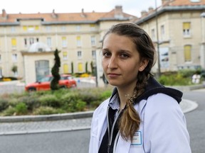 French hospital psychologist Diane Hekking, 28, who refuses to get vaccinated even though it may cost her the job and is against France's coronavirus disease (COVID-19) restrictions, including a compulsory health pass and vaccination for medical workers, stands outside Paul Giroud Hospital in Villejuif, France August 17, 2021.