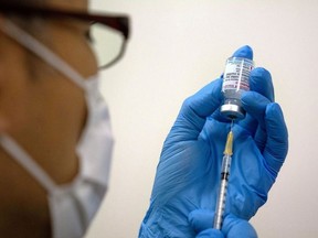 FILE PHOTO: staff prepares Moderna coronavirus disease (COVID-19) vaccine to be administered at the newly-opened mass vaccination centre in Tokyo, Japan, May 24, 2021.