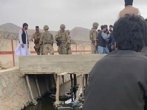 American and Afghani troops speak to an evacuee at the north gate of Hamid Karzai International Airport in Kabul, Afghanistan on Saturday, Aug. 21 2021.