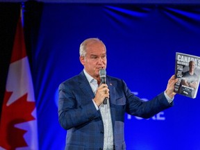 Conservative Leader Erin O'Toole holds a copy of "Canada's recovery plan" as he speaks to supporters at a campaign stop in Hamilton on Wednesday, Aug. 25, 2021.