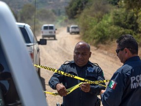 Police officers hold a police cordon at the scene where two young American children were found dead, in Rosarito, Baja California state, Mexico Aug. 9, 2021. Picture taken Aug. 9, 2021.