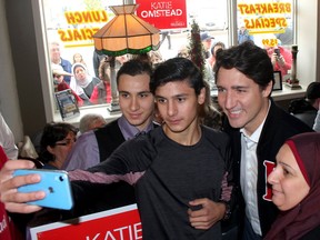 Members of the first Syrian family sponsored by the community to come to Chatham-Kent — Hamid Alhajjeh, 19, left, his brother Mulham Allajjeh, 18, and their mother Noura Alchreifi — pose for a selfie with Prime Minister Justin Trudeau during his stop in Tilbury in 2019.