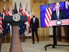 U.S. President Joe Biden walks to the podium before his remarks on an international security initiative involving the United States, the U.K. and Australia. British Prime Minister Boris Johnson (right) joined virtually on September 15, 2021.