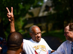Bill Cosby flashes a "V" sign as he is welcomed outside his home after Pennsylvania's highest court overturned his sexual assault conviction and ordered him released from prison immediately, in Elkins Park, Pennsylvania, U.S., June 30, 2021.