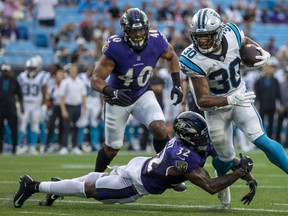 Carolina Panthers' Chuba Hubbard runs the ball against Baltimore Ravens'  DeShon Elliott during a pre-season game.