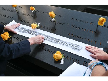 Four sisters make a charcoal imprint of the name of their cousin Richard Avery Aronow during a ceremony at the National September 11 Memorial & Museum commemorating the 20th anniversary of the September 11th terrorist attacks on the World Trade Center on Sept. 11, 2021 in New York City.