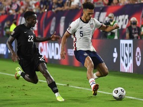 United States defender Antonee Robinson (5) dribbles the ball against Canada defender Richie Laryea (22) in the second half during a CONCACAF FIFA World Cup Qualifier soccer match at Nissan Stadium in Nashville, Tenn., on Sept. 5, 2021.