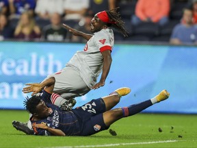 FC Cincinnati forward Isaac Atanga (23) slide tackles Toronto FC forward Ifunanyachi Achara (99) on Saturday.