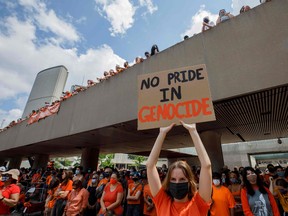 People hold signs and gather during the Every Child Matters walk in honour of indigenous children who lost their lives in Canada's residential school system, in Toronto on July 1, 2021.