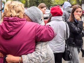 Women react as students evacuate a building of the Perm university campus in Perm on September 20, 2021 following a shooting.