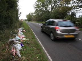 In this file photo taken on October 10, 2019, floral tributes lay on the roadside near RAF Croughton in Northamptonshire, central England,  at the spot where British motorcyclist Harry Dunn was killed as he travelled along the B4031 on August 27.