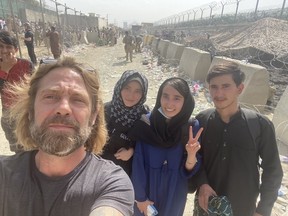 Ark Salus member Travis Peterson with three siblings rescued from Afghanistan.