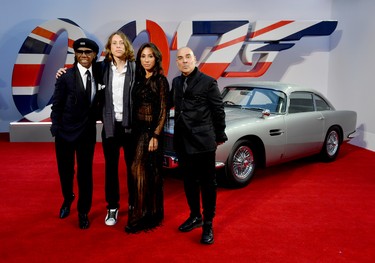 Nile Rodgers (left), guest, guest, and Merck Mercuriadis (right) stand next to James Bond's Aston Martin at the World Premiere of "No Time To Die" at the Royal Albert Hall in London, England, Tuesday, Sept. 28, 2021.