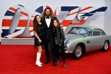 Lola Iolani Momoa, Jason Momoa and Nakoa-Wolf Manakauapo Namakaeha Momoa stand next to James Bond's Aston Martin at the World Premiere of "No Time To Die" at the Royal Albert Hall in London, England, Tuesday, Sept. 28, 2021.