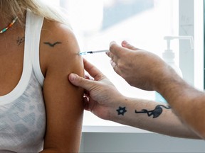 An Israeli woman receives a third shot of a COVID-19 vaccine in Tel Aviv, Israel, Aug. 30, 2021.