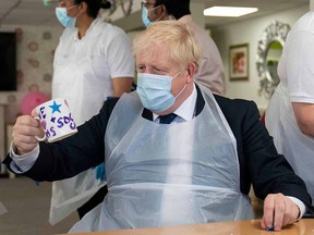 Britain's Prime Minister Boris Johnson gestures as he visits Westport Care Home in east London on September 7, 2021.
