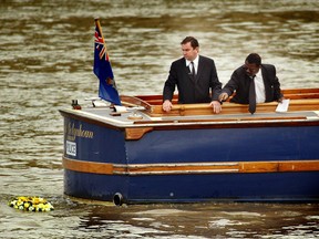 Detective Inspector Will O'Reilly (L) and John Azah of the Independent Advisory Group place a wreath in the River Thames September 21, 2002 at the place where the torso of a boy, who police have called 'Adam', was found a year earlier.