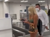 In a viral video, a mask-wearing woman decked out in a bikini walked through an airport.