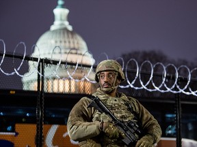 A National Guardsman stands outside the razor wire fencing that surrounds the U.S. Capitol on January 15, 2021 in Washington.