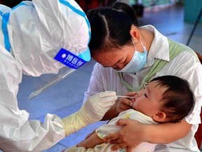 A child undergoes a nucleic acid test for the Covid-19 coronavirus in Xianyou county, Putian city, in China's eastern Fujian province on September 13, 2021.
