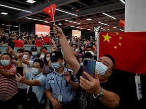 Supporters wave Chinese national flags as they wait for the arrival of Huawei executive Meng Wanzhou at the Bao'an International Airport in Shenzhen on Sept. 25, 2021.
