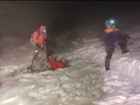 Members of Russia's Emergencies Ministry conduct a rescue operation after a group of climbers got stuck while climbing Mount Elbrus, in the Republic of Kabardino-Balkaria, Russia, in this still image from video taken Sept. 23, 2021.