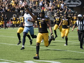 Tiger Cats' Frankie Williams holds the ball high as he completes his 67-yard touchdown punt return against the Argos in the third quarter in Hamilton, Ont., Monday, Sept. 6, 2021.