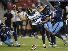 Toronto Argonauts defensive back Jeff Richards (23) separates Hamilton Tiger-Cats wide receiver Jaelon Acklin from the football in the first half of their CFL football game in Toronto, Friday, Sept. 10, 2021.