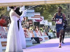 Spectators applaud as winner Ethiopia's Derara Hurisa reaches the finish area during the 38th edition of the Vienna City Marathon in Vienna, Austria, on Sept. 12, 2021.