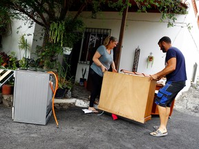 Residents evacuate a home following the eruption of a volcano on the Canary Island of La Palma, in La Laguna, Spain, September 21, 2021.