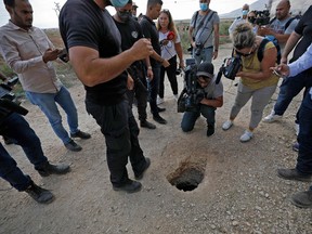 Police and journalists gather around a hole used by six Palestinian prisons to escape from the Gilboa Prison after they dug a tunnel beneath a sink, in northern Israel on September 6, 2021.