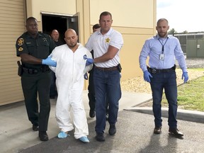 Quadruple murder suspect Bryan Riley is led from the Polk County Sheriff’s Office in Lakeland, Fla., on Sunday.