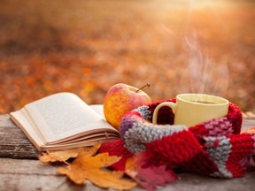 Tea mug with warm scarf open book and apple